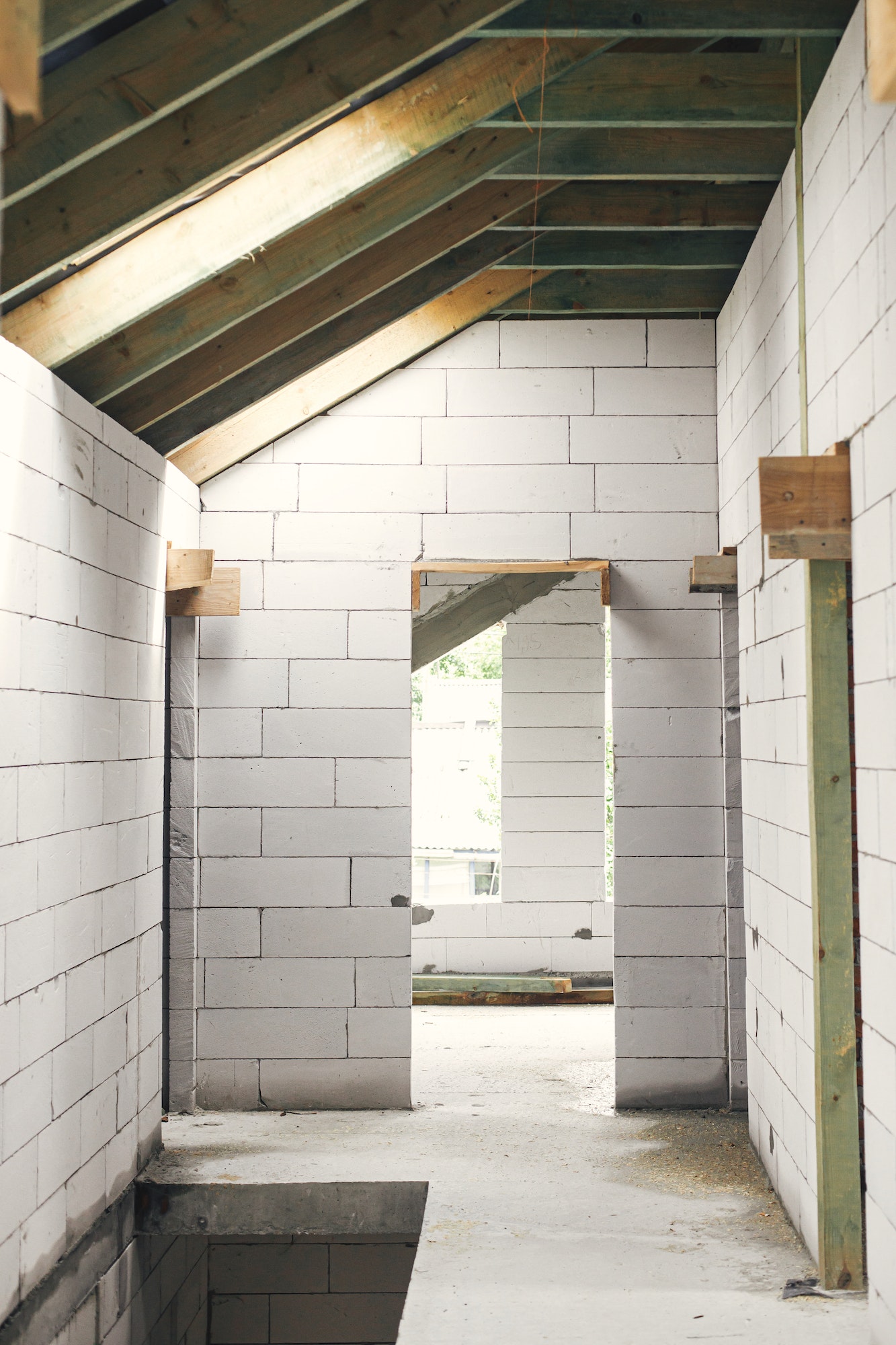Unfinished attic wooden roof framing with vapor barrier, dormer and windows. New house constructio